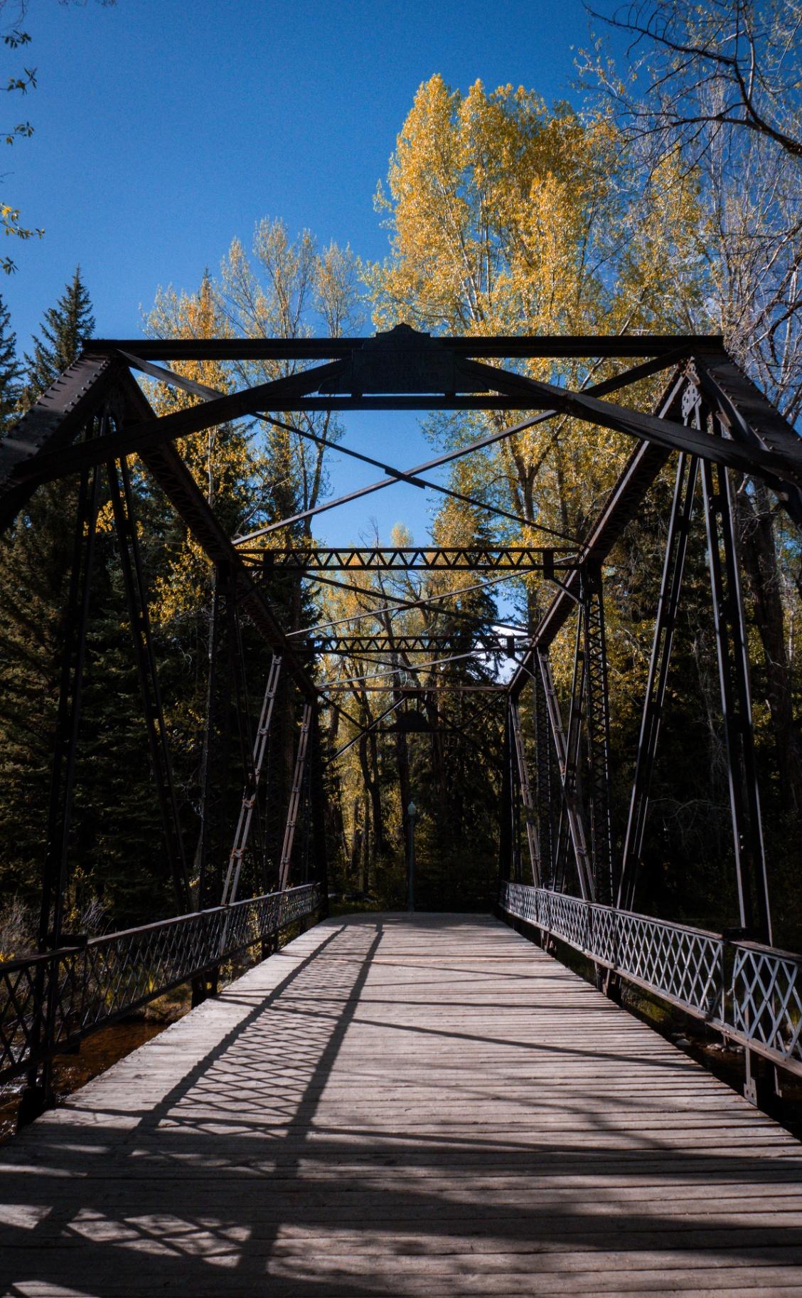 Historic iron bridge with golden aspens