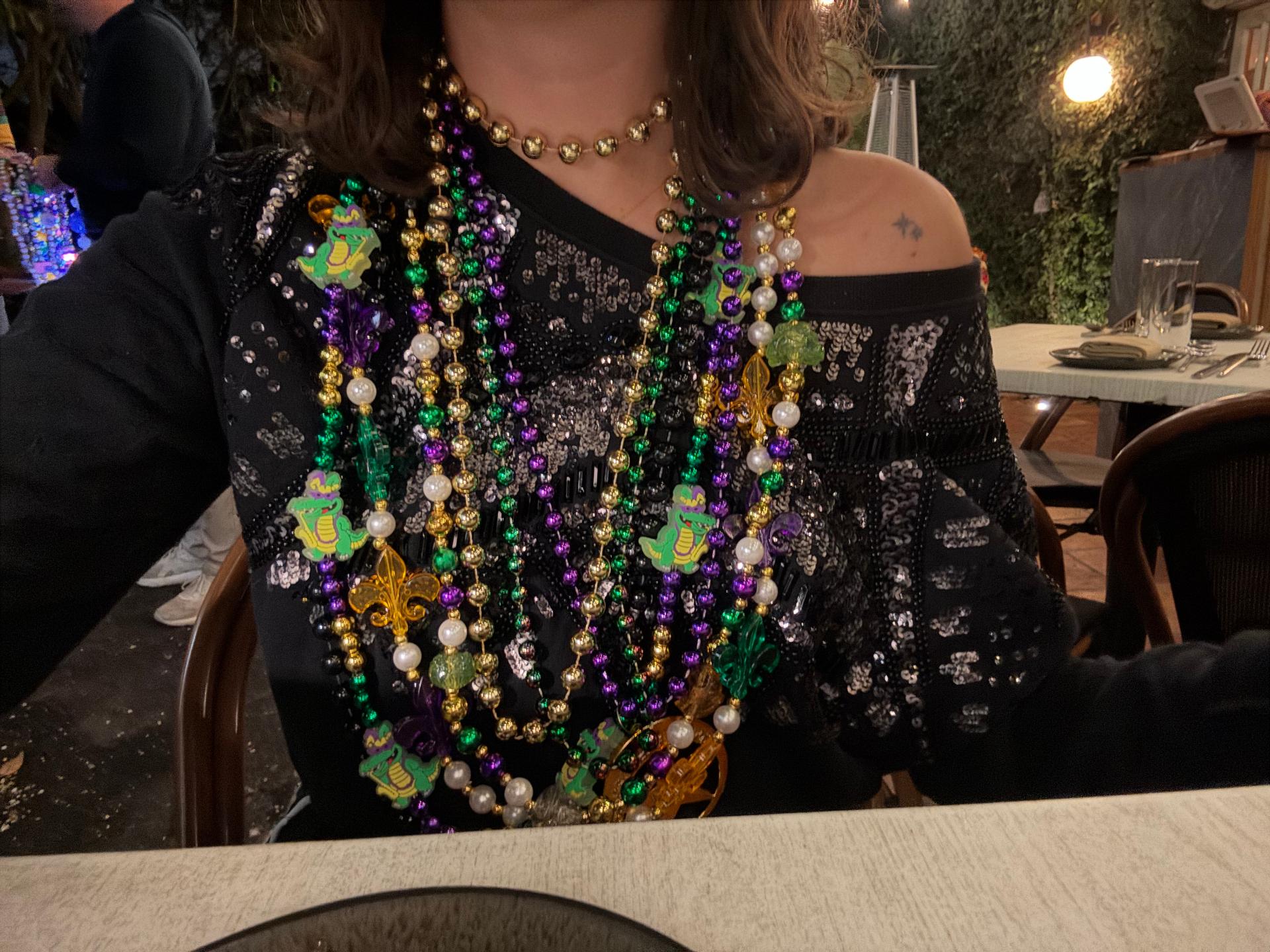 Mujer con top de lentejuelas cubierta de collares en la cena