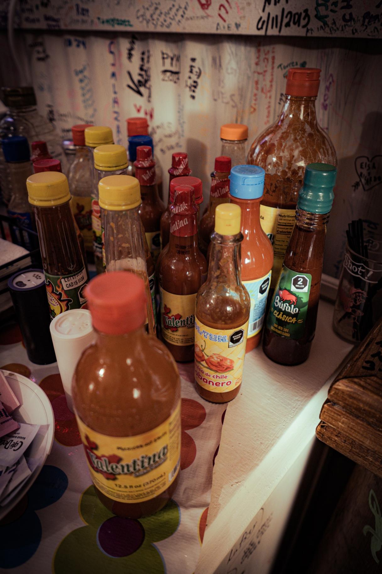 Botellas de salsa picante en Marfa Burrito
