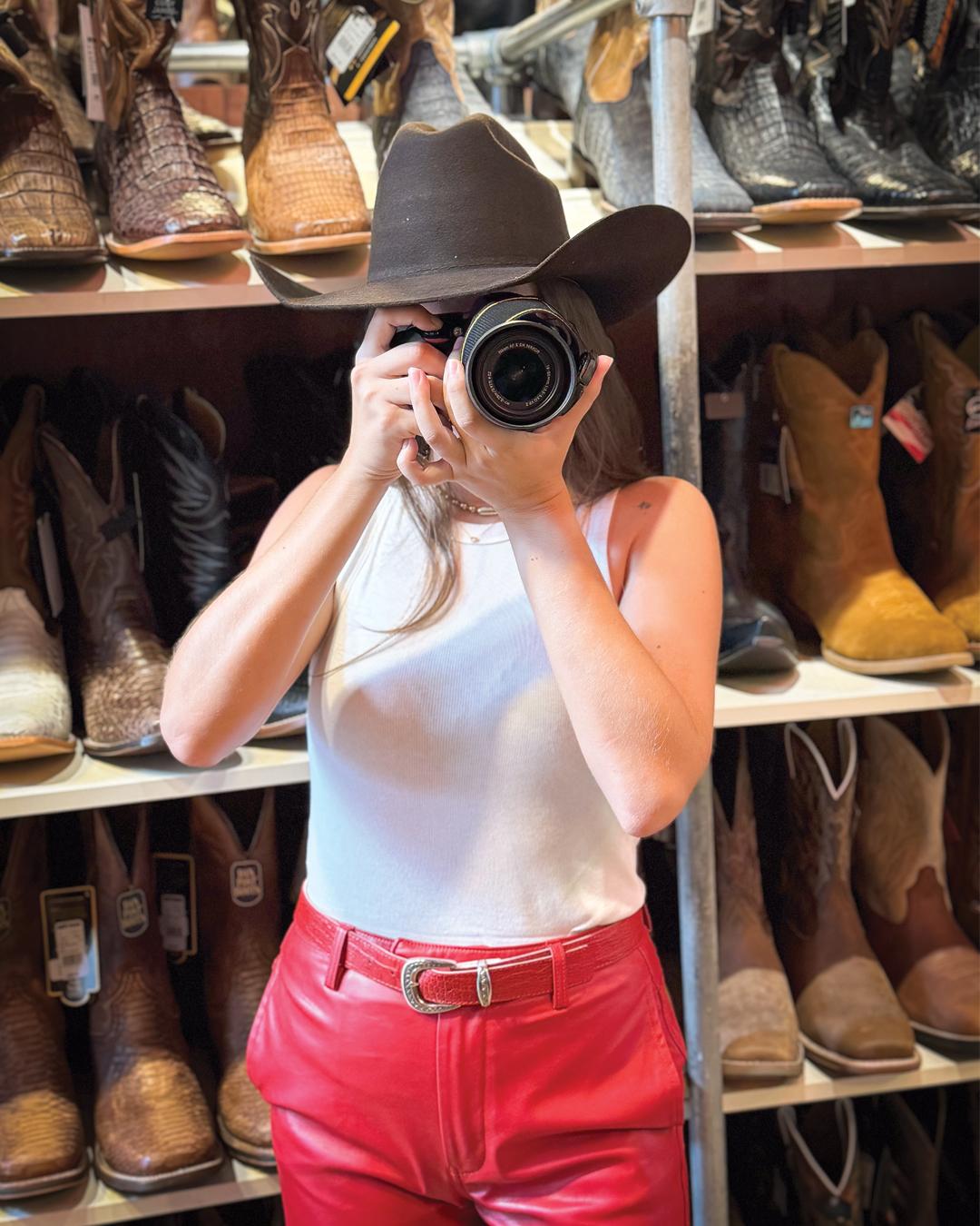 Sombrero vaquero y cámara en la tienda de botas
