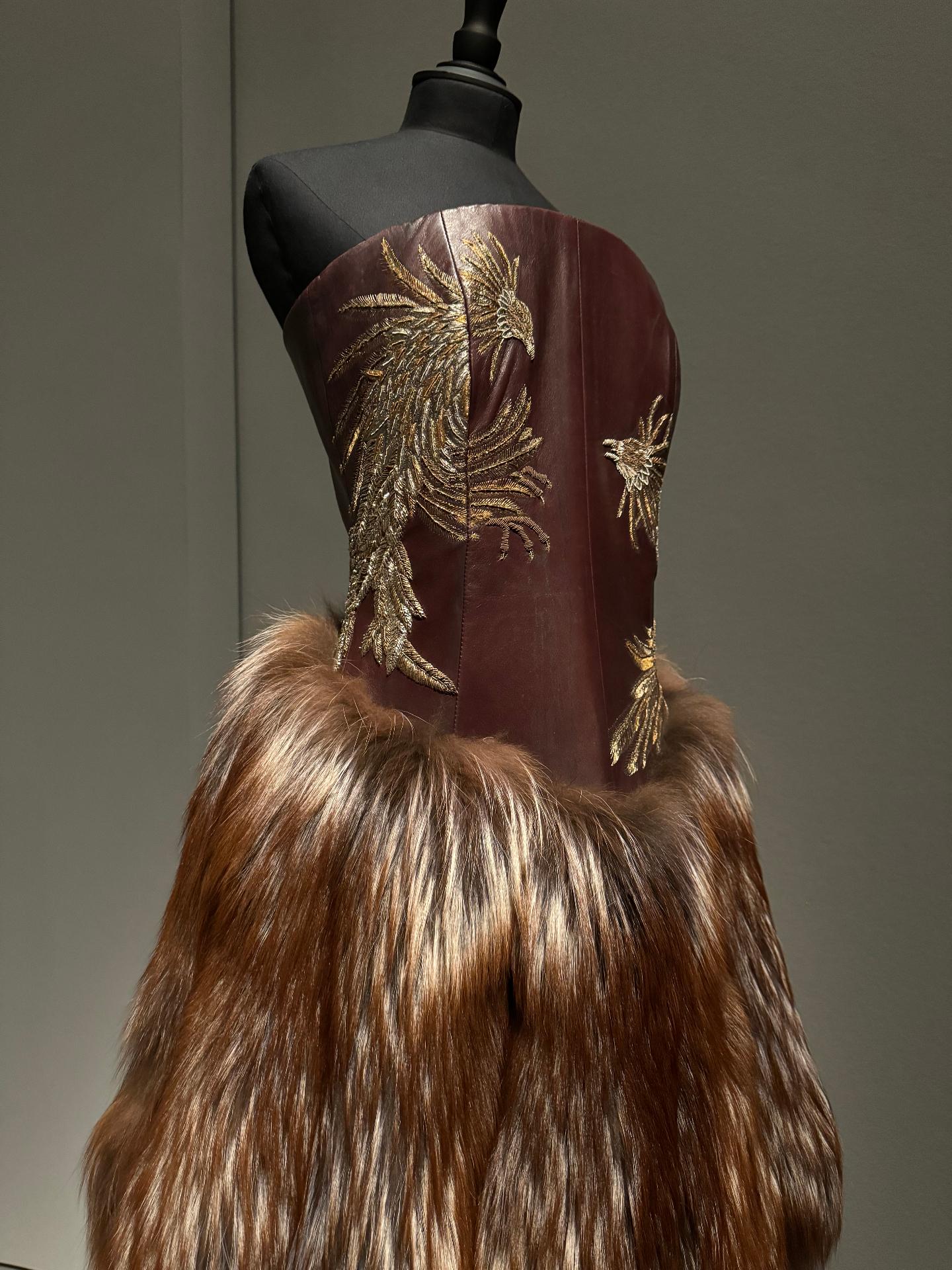 Vestido marrón de McQueen con bordado dorado de fénix