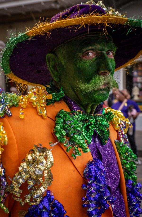 Green-painted reveler in Mardi Gras costume