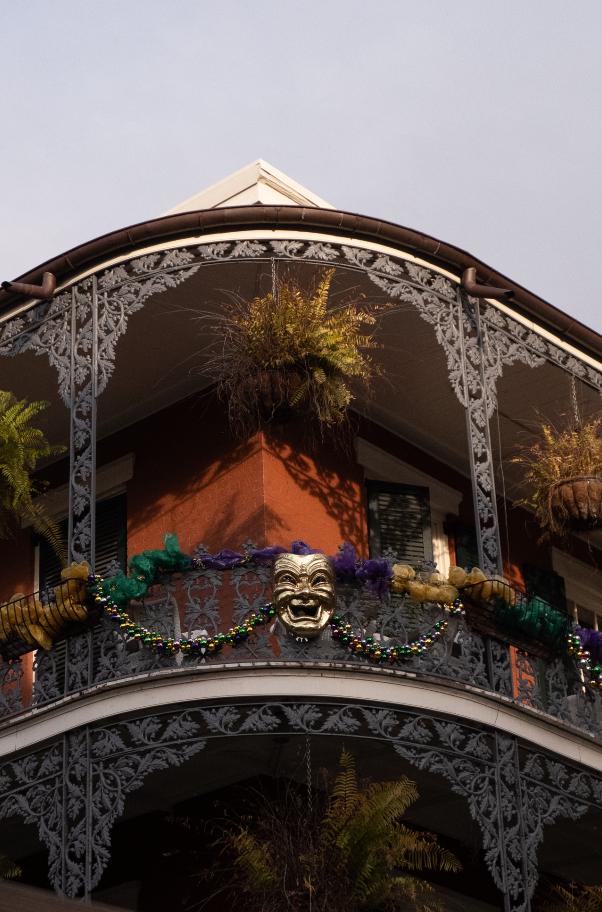 French Quarter balcony adorned with Mardi Gras mask