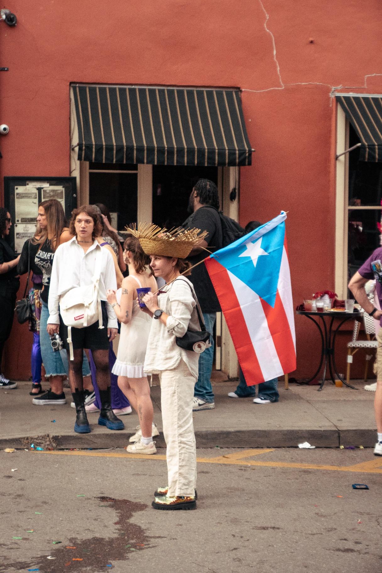 Persona con bandera de Puerto Rico durante Mardi Gras